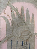 Close-up shot of a pink and grey embroidered wallhanging made from a cushion cover second depicting a broken hand sewed back together