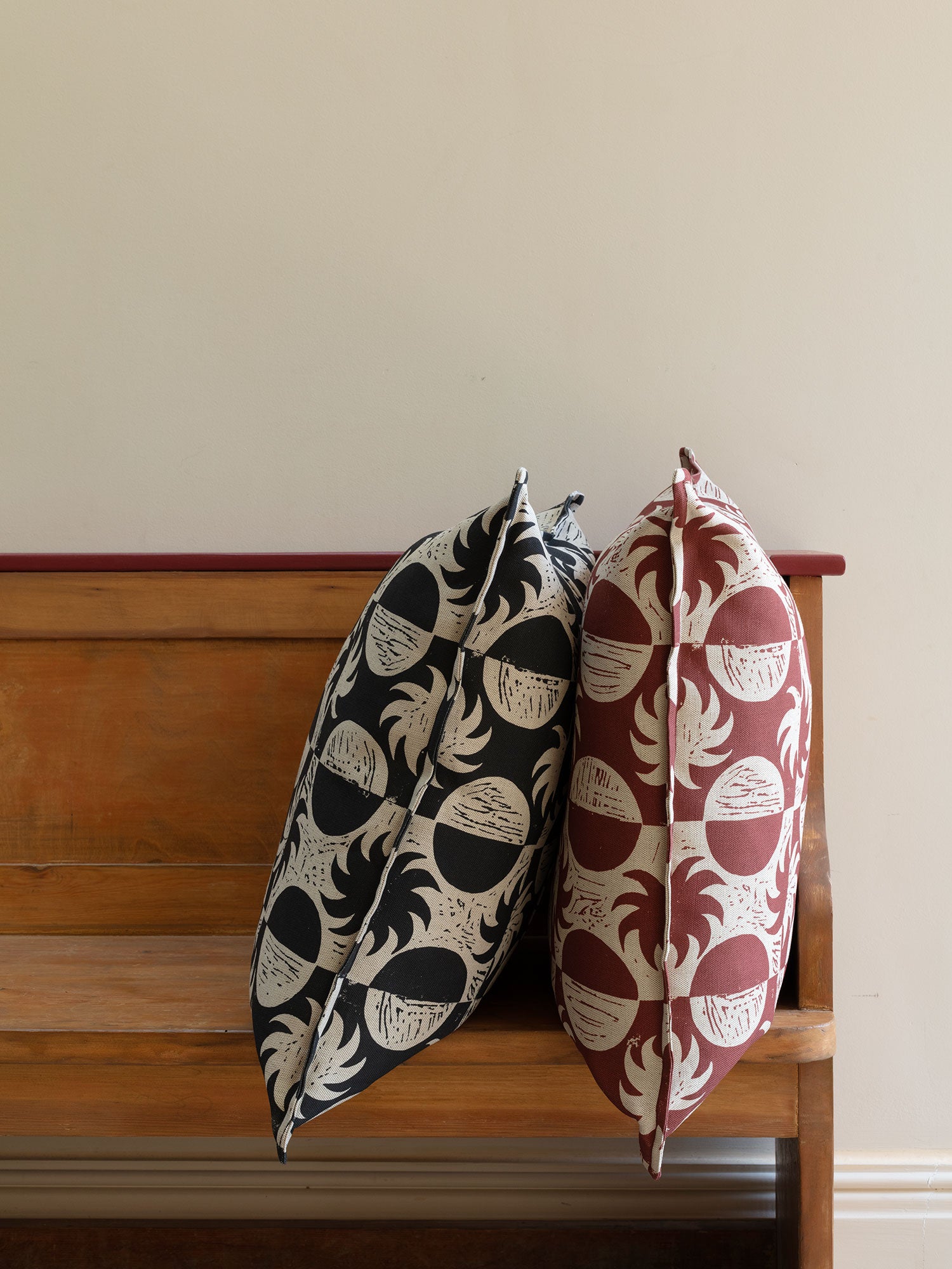 Cushions with red and white, and black and white sun and moon print fabric on wood bench
