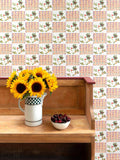 Maximalist white wallpaper combining Arts & Crafts with West African textiles, with a detail from a William Morris wall hanging, pictured with sunflowers and a bowl of cherries on a bench