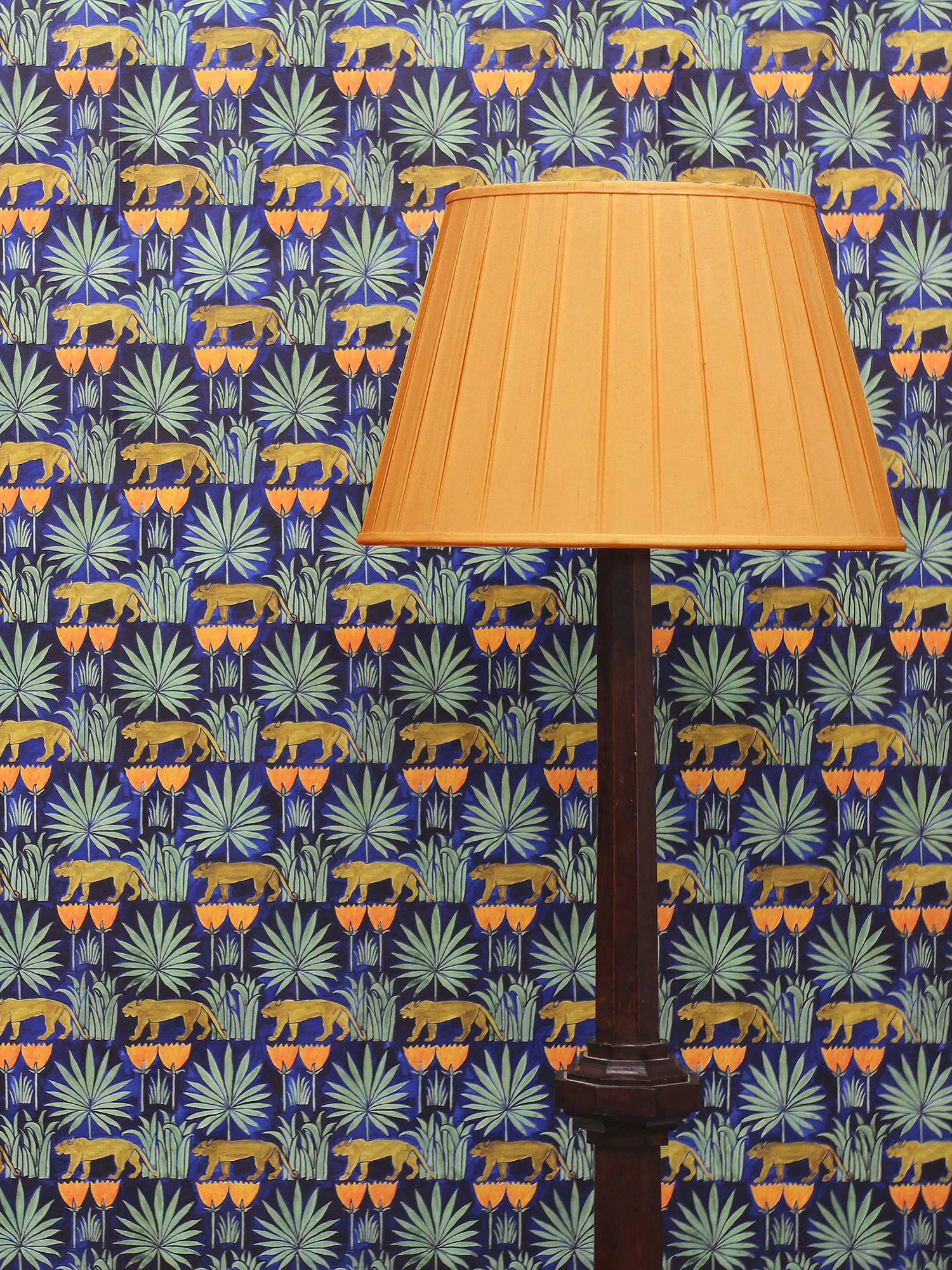 A tropical Arts & Crafts design in midnight blue, yellow and green, based on a 1918 watercolour drawing by Voysey found in the V&A archive, pictured with a yellow lampshade