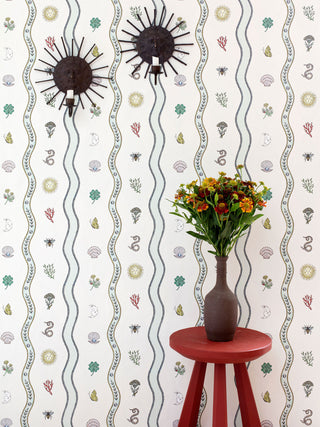 Wallpaper with mystical motifs in dip-pen by illustrator Fee Greening - shells, butterflies, flowers, the sun and moon and more, pictured with flowers and wall sconces