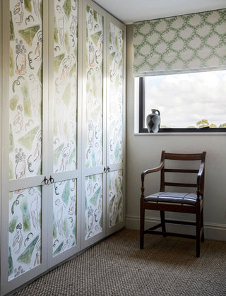 Inspired by the Bloomsbury set, this wallpaper in pink and green features cheeky Neo-Classical nude figures, pictured on dressing room doors next to window