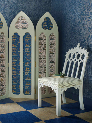 This domino paper in a Prussian blue colourway features exotic and earthly animals - elephants, lions, horses, and dogs - with added magic in the form of a unicorn, pictured with room divider and chair